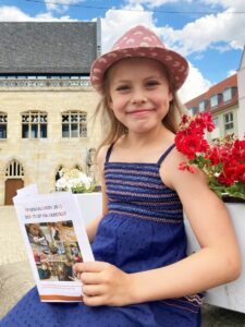 HBS_Ferienkalender2022_Nicole Huhn: Emilia (7) freut sich schon auf die Sommerferien und stöbert im Ferienkalender der Stadt Halberstadt.